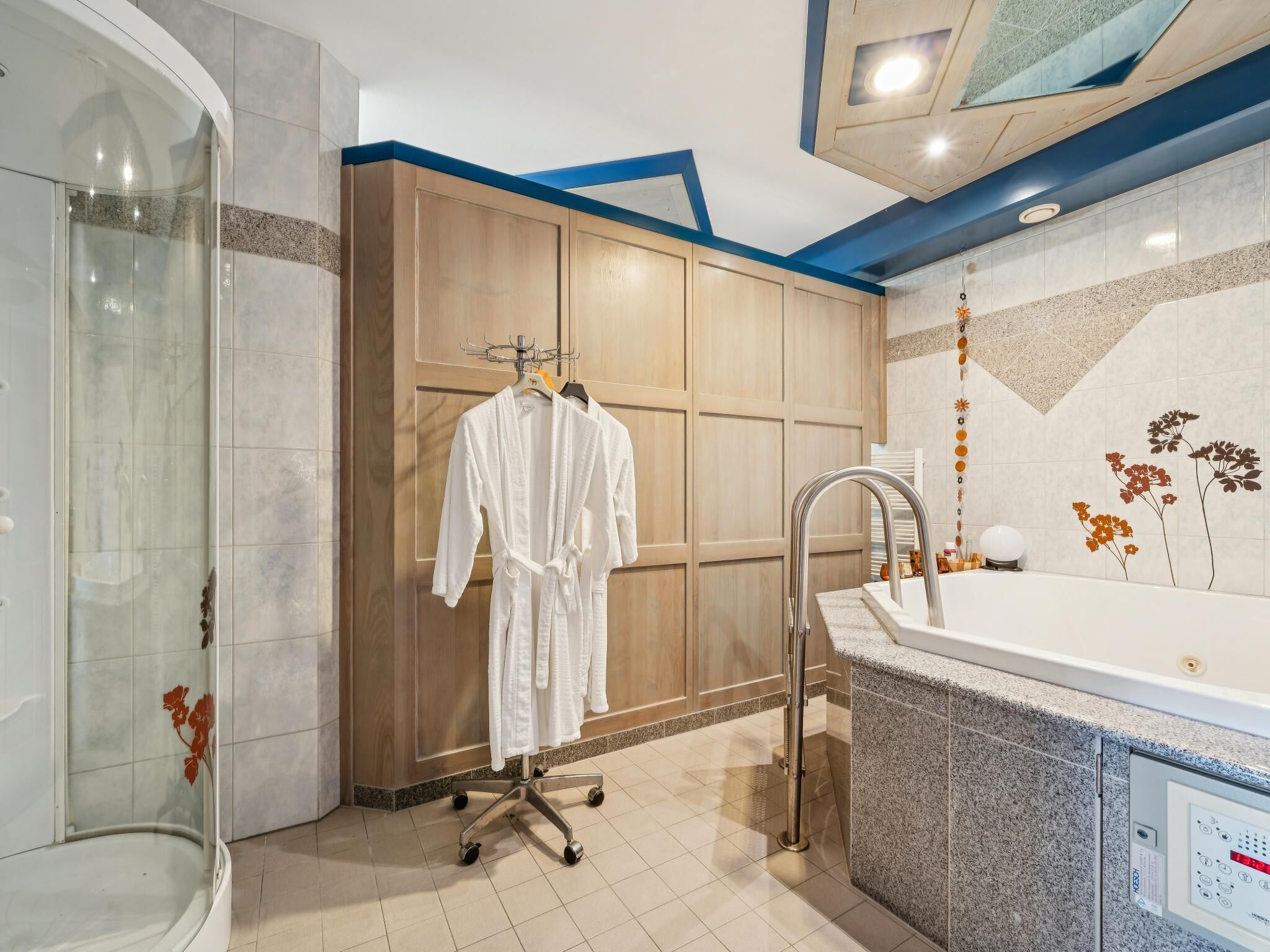 Une salle de bain moderne avec une douche à l’italienne, une grande baignoire et un porte-peignoir.