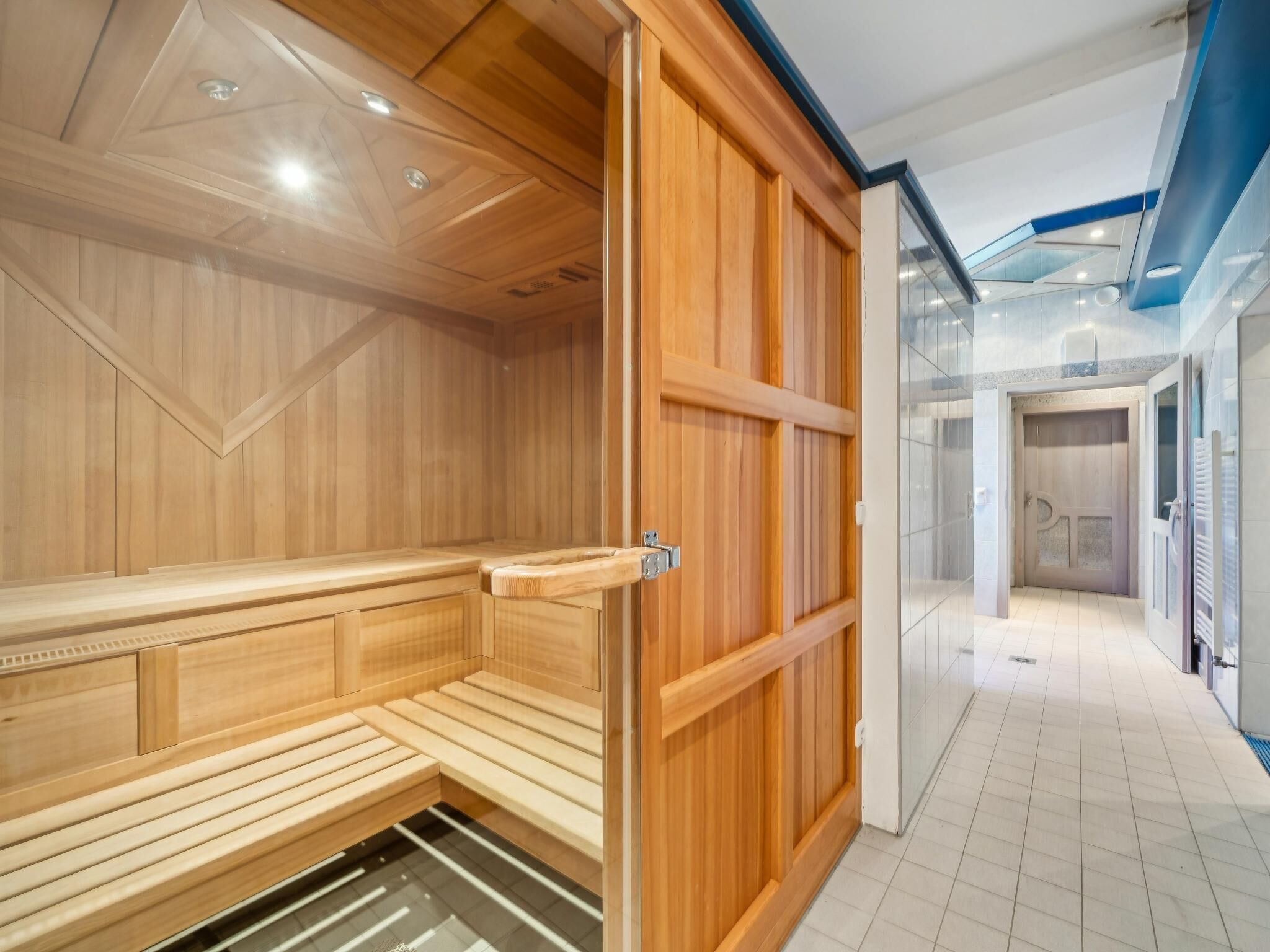 A sauna room with wooden benches and a sliding door.