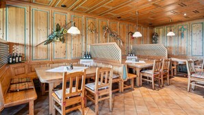 Interior de madera con techo alto, bancos, mesas y sillas.