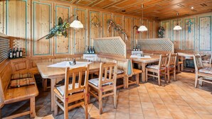 A wooden interior with high ceilings, a central dining table surrounded by chairs, and a seating area with benches. - Quiet holiday apartment in the Bavarian Forest (Waldkirchen)