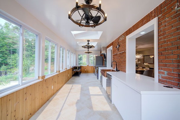 A modern kitchen with large windows, a brick accent wall, and a central island. - Privacy Magical Forest Cottage 30+ Party Room,  Disco KTV (Uxbridge)