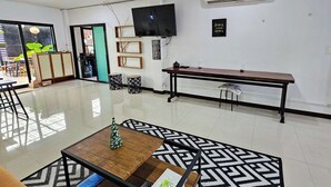 Un vestíbulo amplio con una mesa de centro de madera, alfombra estampada y un banco.