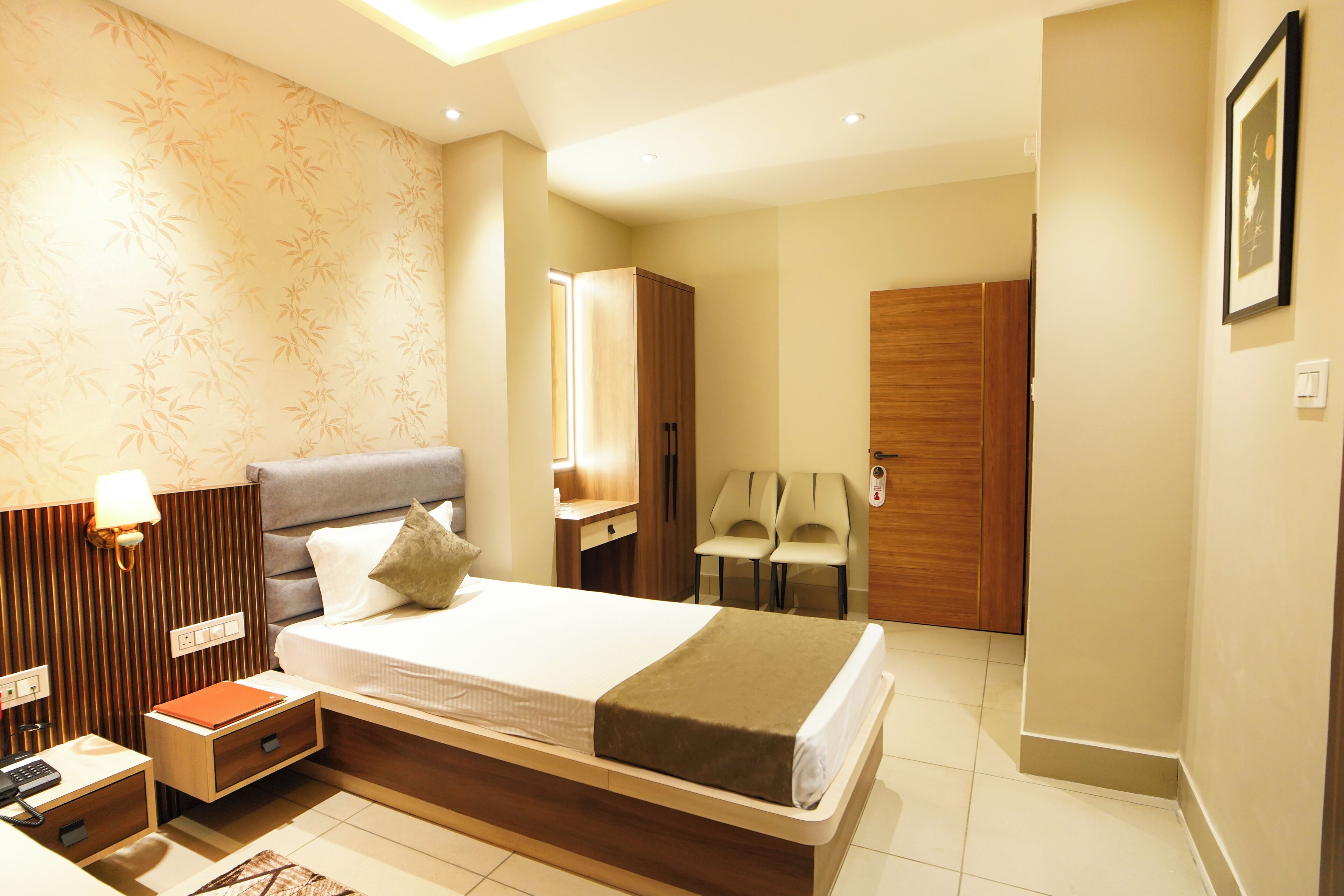 Une chambre d’hôtel avec un lit, une table de chevet, une lampe et un miroir.