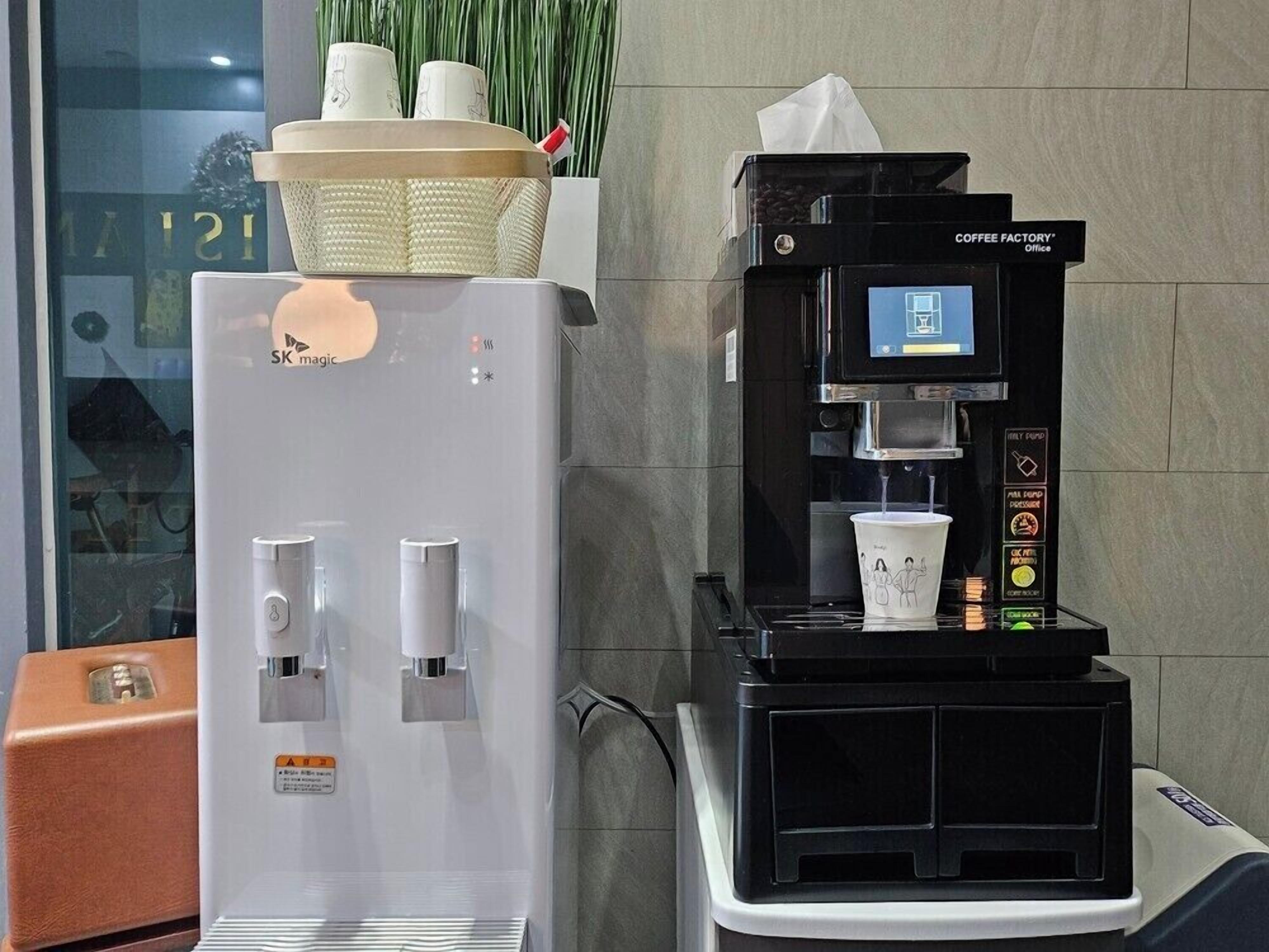 Une machine à café et un distributeur d’eau sont à disposition dans un espace public.