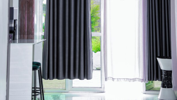 Una habitación moderna con ventanas amplias, una zona de cocina y un espacio para sentarse.