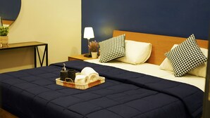 A hotel room with a bed, a bedside table, a lamp, and a tray with toiletries. - Lumiere Hotel Islamabad (Islamabad)