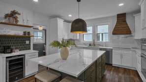 A modern kitchen with white cabinets, a marble island, and a pendant light. - Downtown, Historic, Newly Renovated (Raleigh)