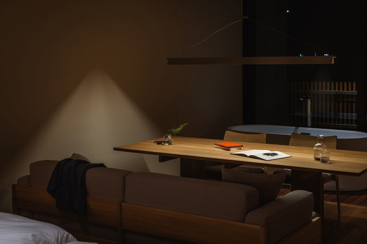 Una habitación moderna con una mesa de comedor de madera, un sofá y una cama.