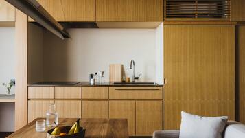 A modern kitchen with wooden cabinets, a black countertop, and a dining area with a table and chairs.