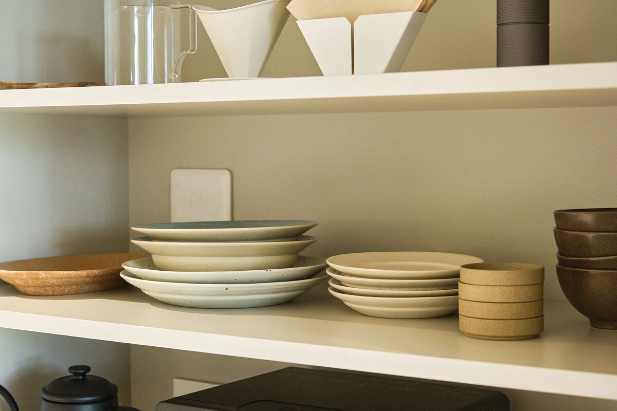 A kitchen shelf with various ceramic dishes and containers.