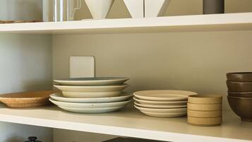 A kitchen shelf with various ceramic dishes and containers.