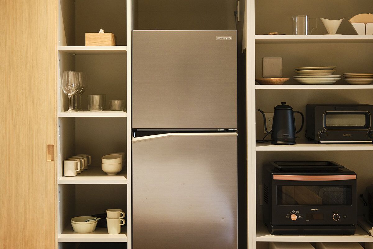A kitchen with a refrigerator, microwave, and toaster.