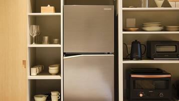 A kitchen with a refrigerator, microwave, and toaster.