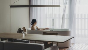 A modern bathroom with a freestanding bathtub, a wooden table, and a chair. - SANU 2nd Home Tateyama 1st (Tateyama)