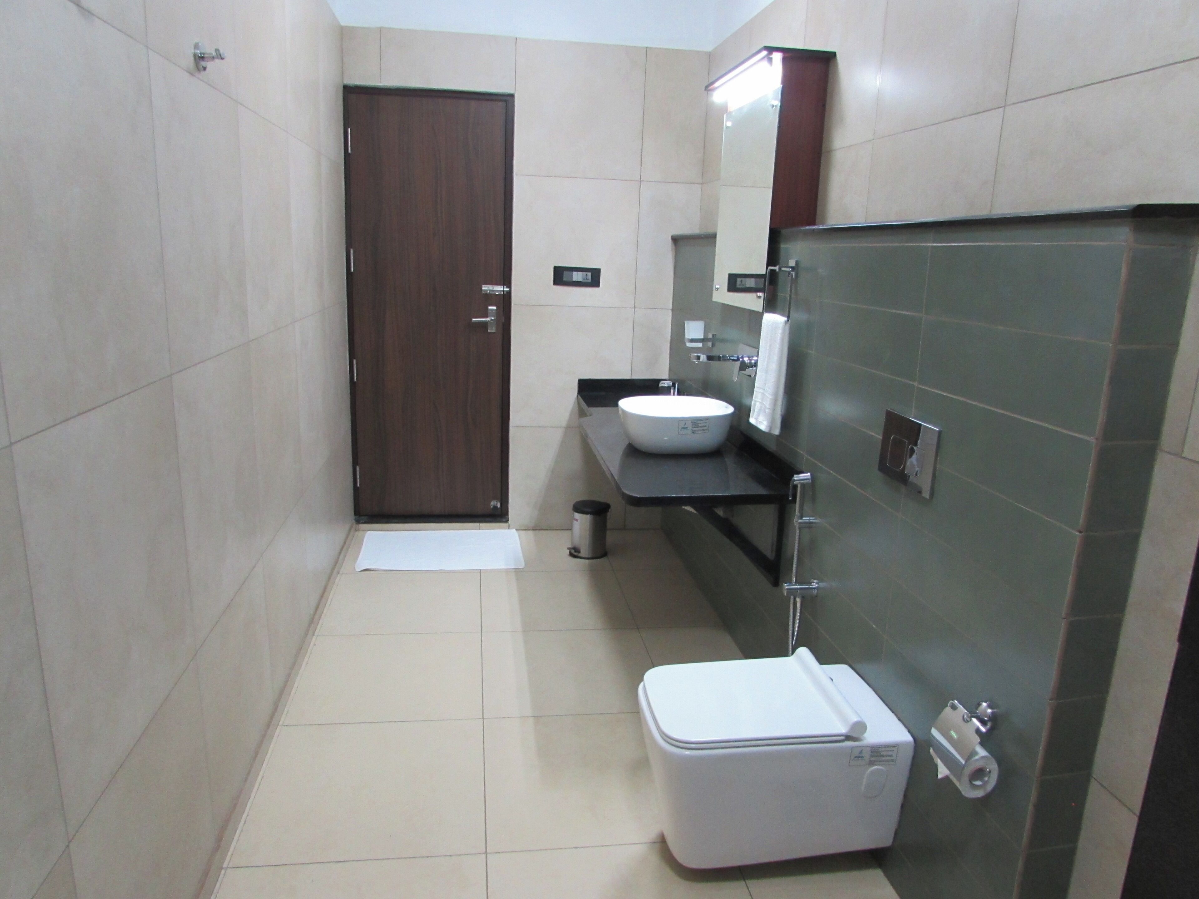 Un baño pequeño y moderno con inodoro, bidé y lavamanos.