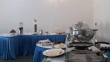 Montaje de bufé con diversas opciones de comida, una máquina de café y una estufa.