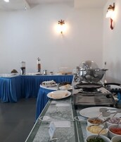 Montaje de bufé con diversas opciones de comida, una máquina de café y una estufa.