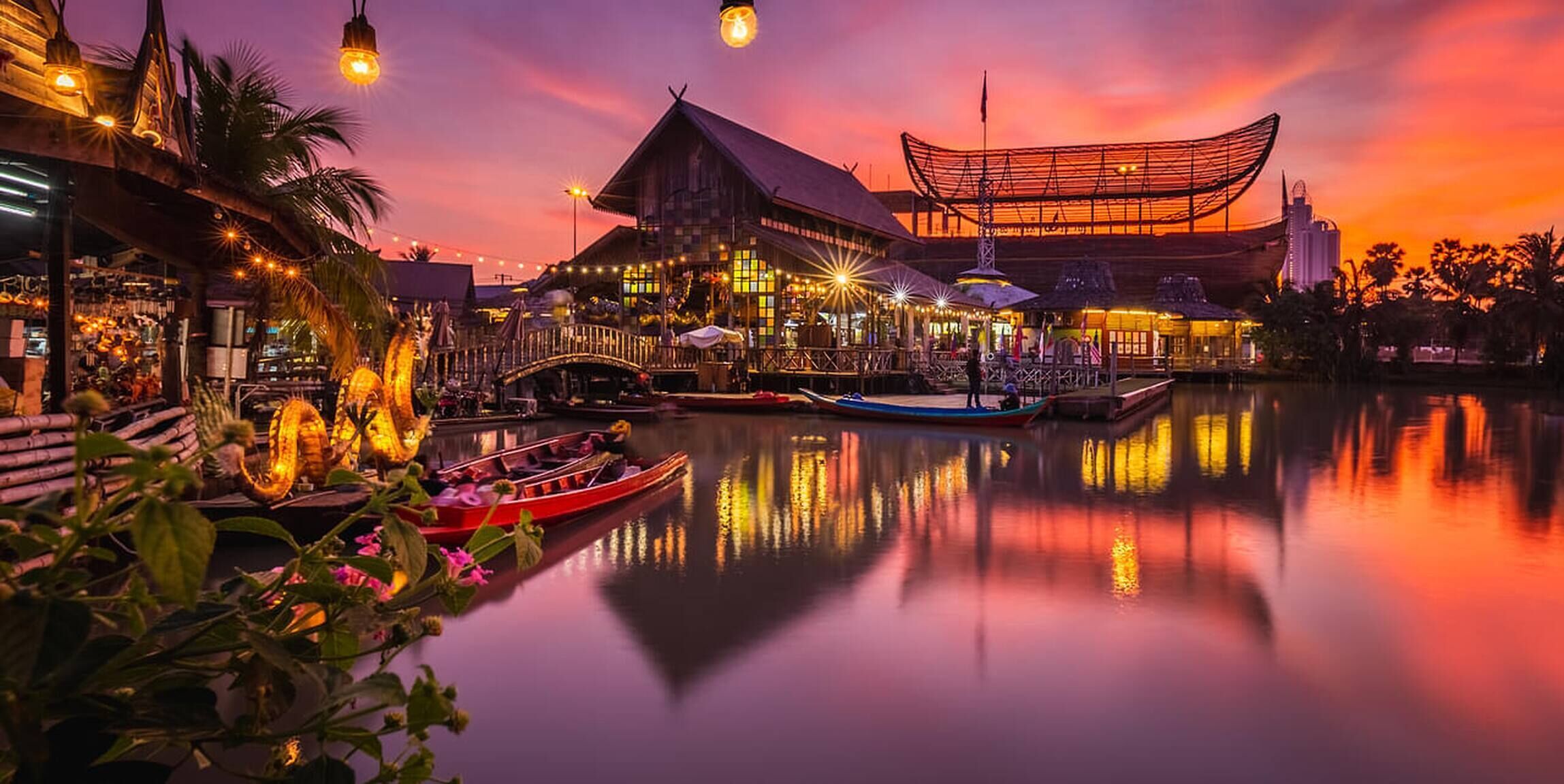 Ein Restaurant am Wasser mit traditioneller asiatischer Architektur, das ein großes, offenes Pavillon und eine Brücke über dem Wasser bietet.