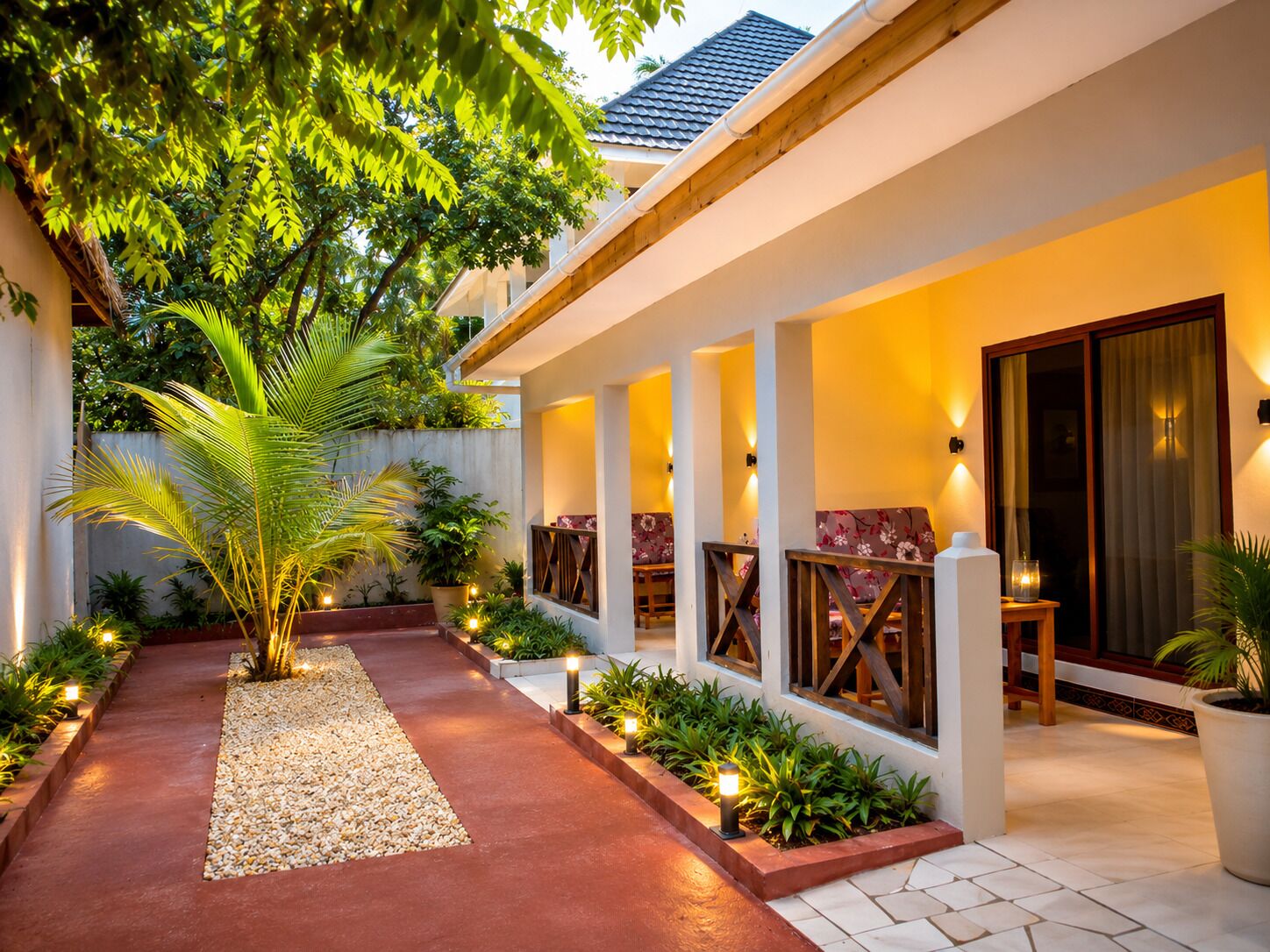 A covered outdoor area with a pathway, seating, and potted plants.