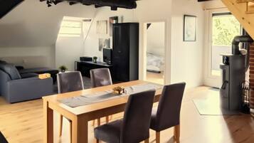 Un espace de vie moderne de style loft, comprenant un coin repas, un canapé et un escalier.