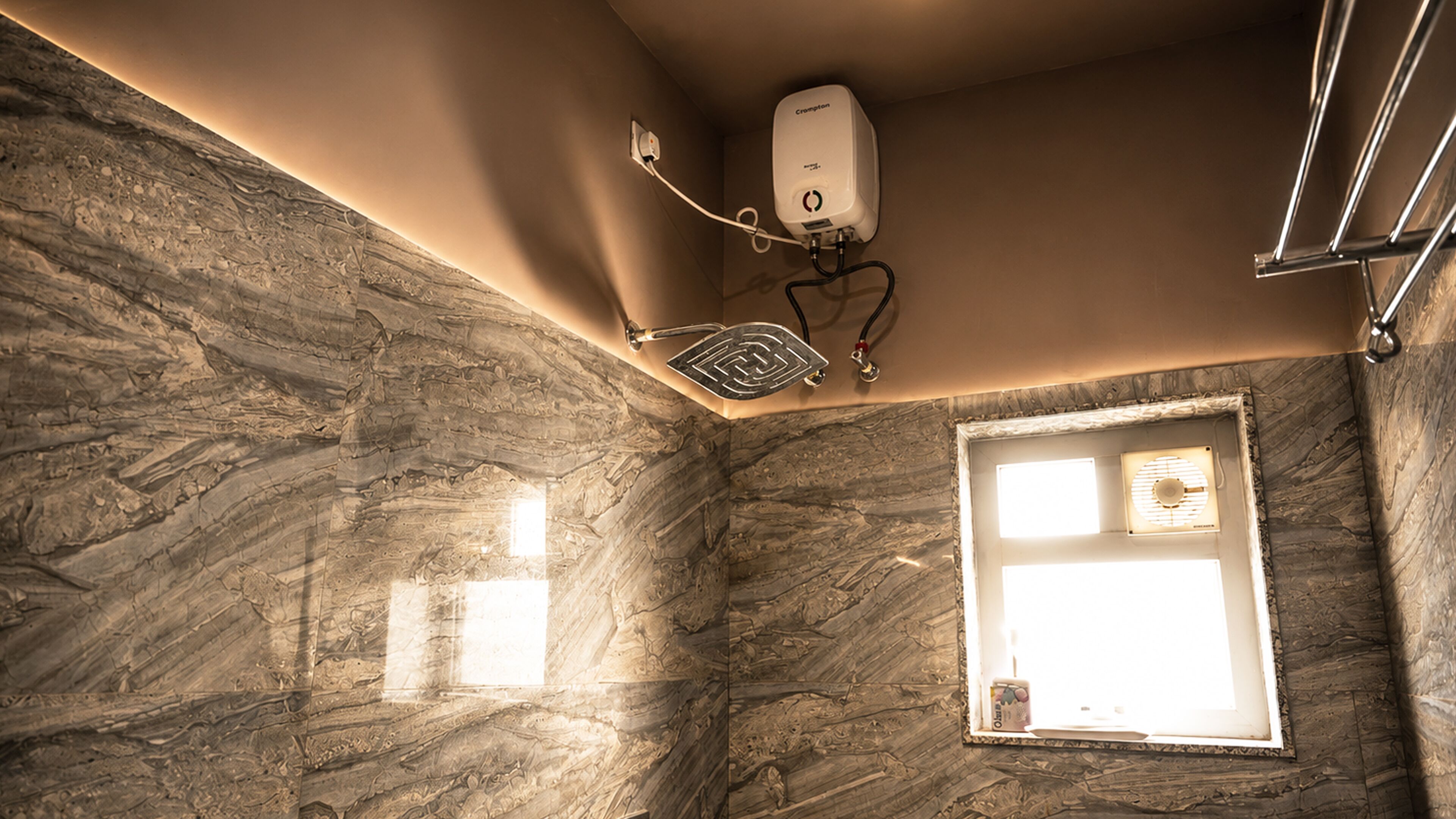 A bathroom with a marble wall, a ceiling-mounted water heater, and a window with blinds.