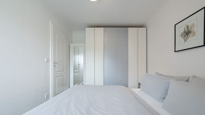 A bedroom with a bed, a wardrobe, and a framed picture on the wall. - Strand - Lust auf Sylt - Apartment Strand for 2 persons (Sylt-Ost)