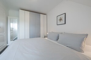 Une chambre à coucher avec un grand lit, une armoire et un tableau encadré au mur.