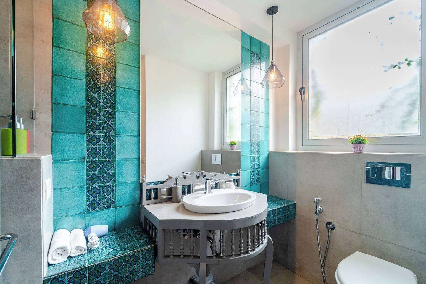 A bathroom with a round sink, a mirror, and a window.