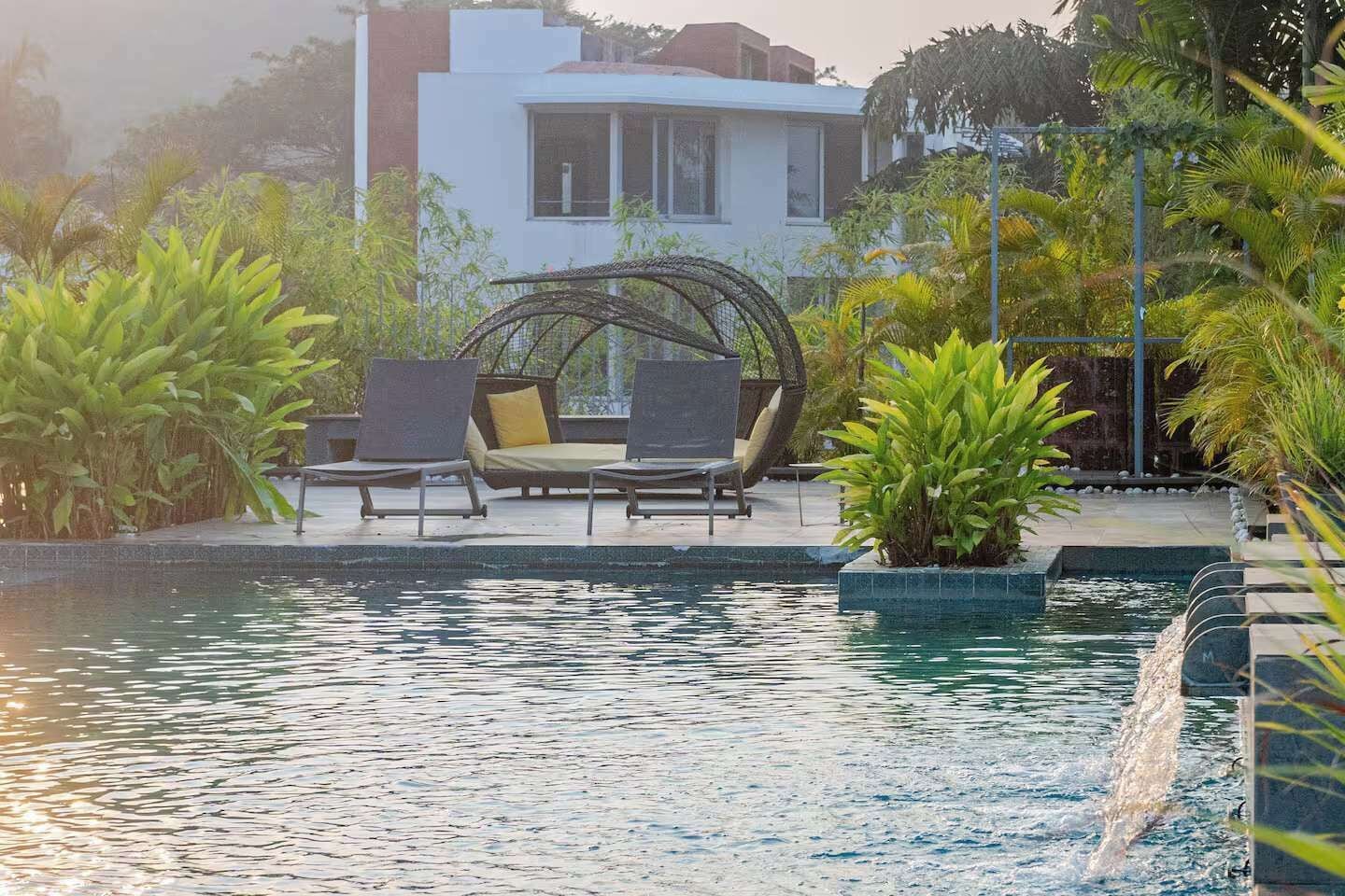 A pool area with lounge chairs and a water feature.