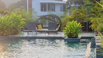 A pool area with lounge chairs and a water feature.