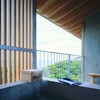 A balcony with a wooden floor, a small wooden box, and a towel on a bench.
