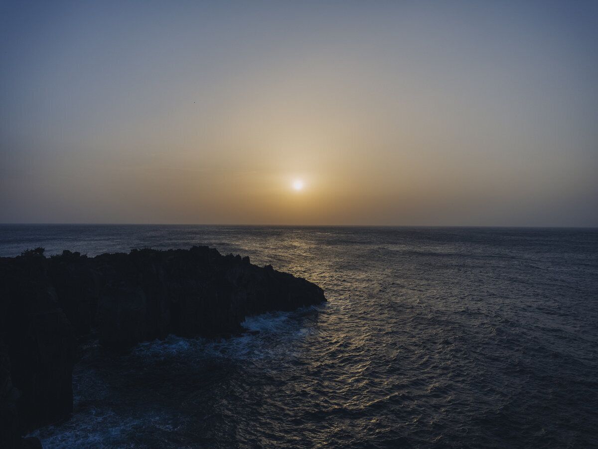 Un atardecer costero con un litoral rocoso.
