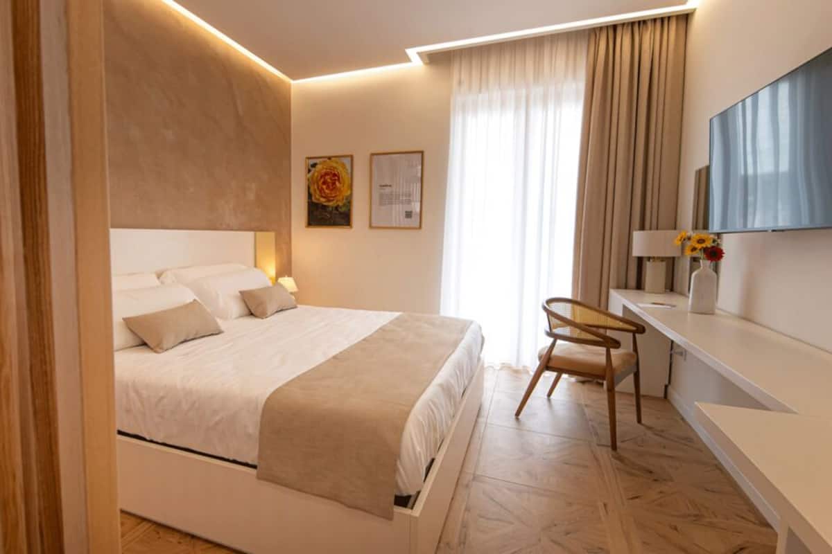 Une chambre moderne avec un grand lit, des tables de chevet, un bureau et une chaise.