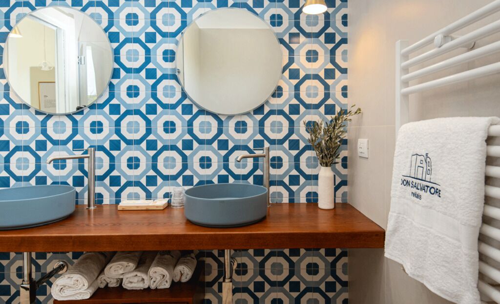 A bathroom with two sinks, a mirror, and a towel rack.