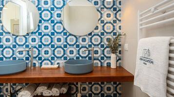 A bathroom with two sinks, a mirror, and a towel rack.