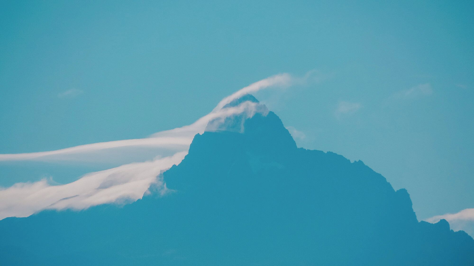 A mountain peak with a cloud formation.