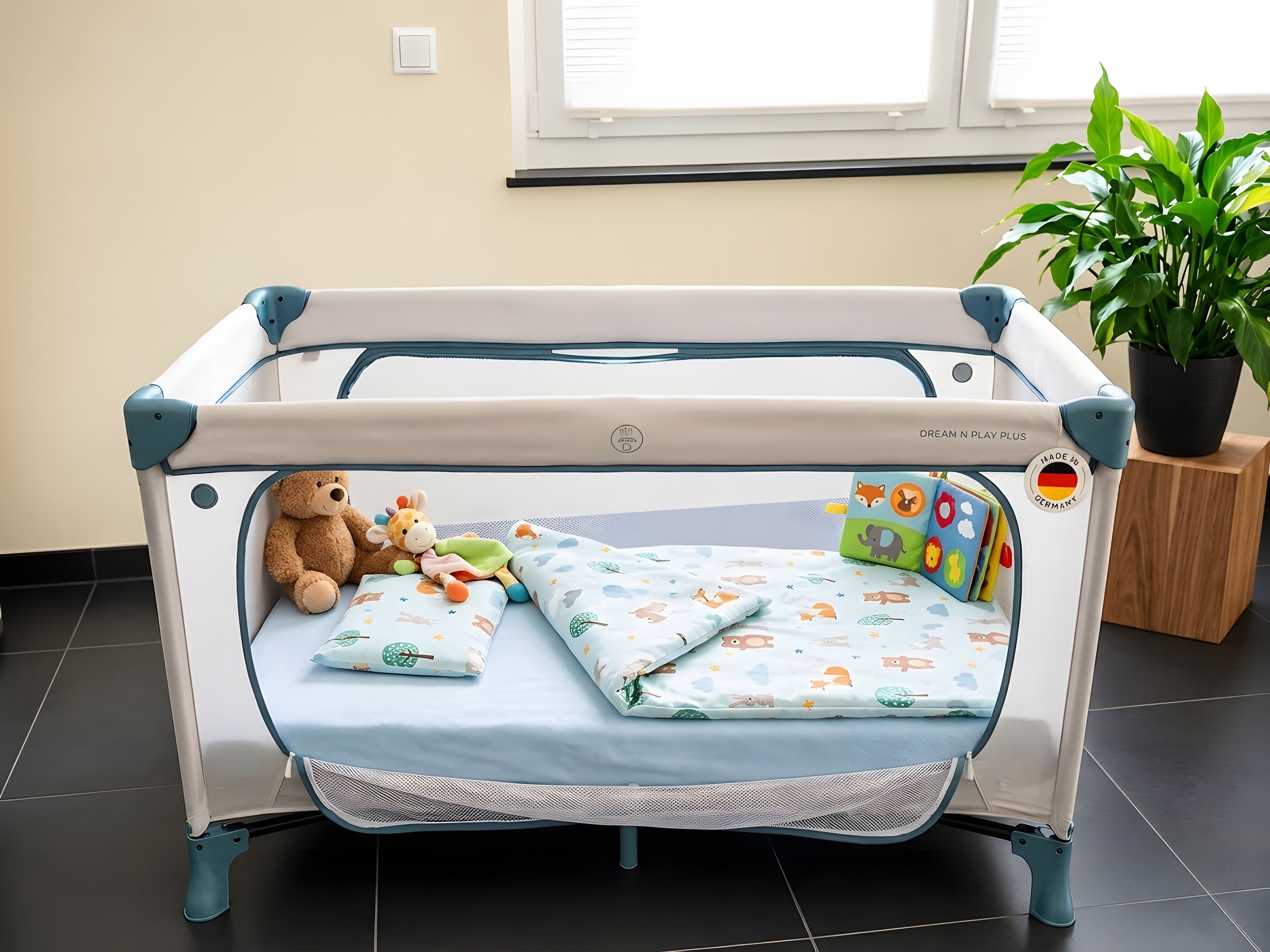 Una cuna infantil con colchón, almohadas y juguetes.