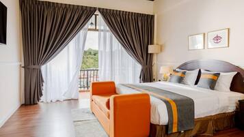 Quarto de hotel com cama grande, sofá e vista para o exterior.