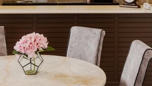 A round table with a marble top, surrounded by four grey upholstered chairs. - SpringHill Resort (Brinchang)