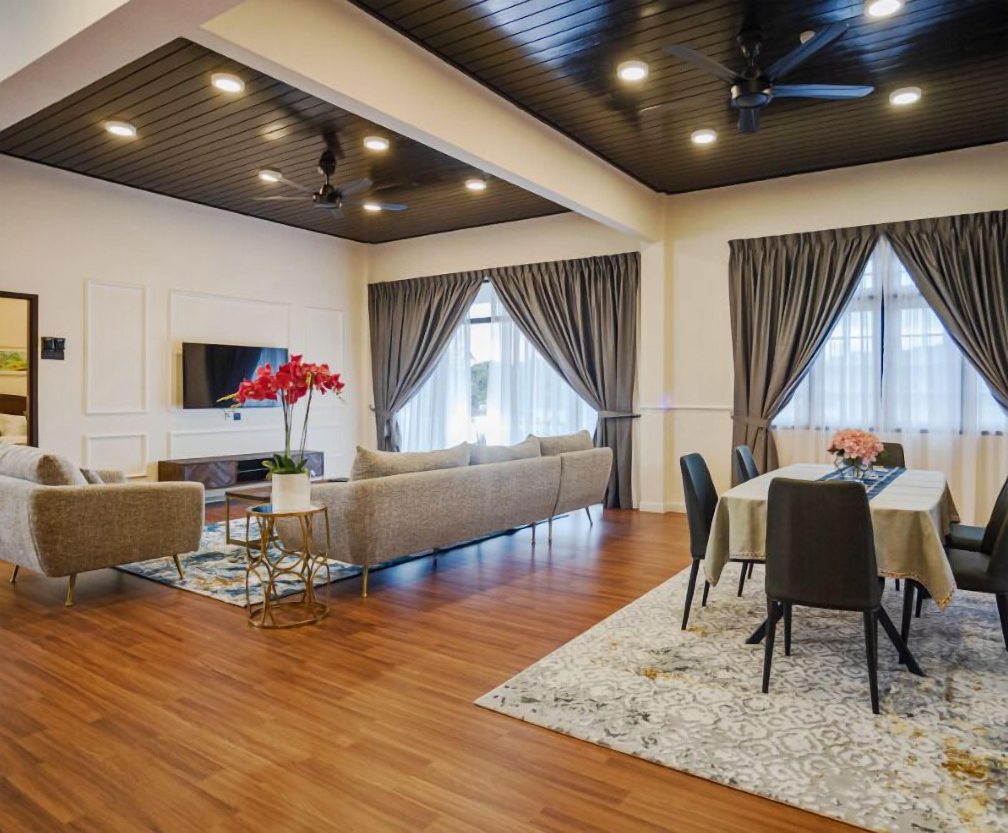 A modern living room with a sofa, a coffee table, and a dining area with chairs and a table.