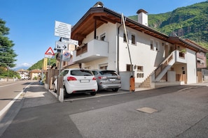 A building with a balcony, a staircase, and a view of a mountain. - Honey Home Apartment with Mountain View, Wi-Fi and Parking (San Giacomo)