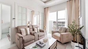 A modern living room with two sofas, a coffee table, and a TV. - Luxury 1BR Lagoon View Arjan near Miracle Garden by Green Sky Holiday Homes (Dubai)