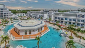 A hotel with a central swimming pool, multiple buildings, and palm trees. - Luxury 1BR Lagoon View Arjan near Miracle Garden by Green Sky Holiday Homes (Dubai)