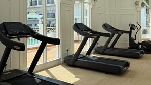 A gym with treadmills, large windows, and a view of balconies. - Luxury 1BR Lagoon View Arjan near Miracle Garden by Green Sky Holiday Homes (Dubai)