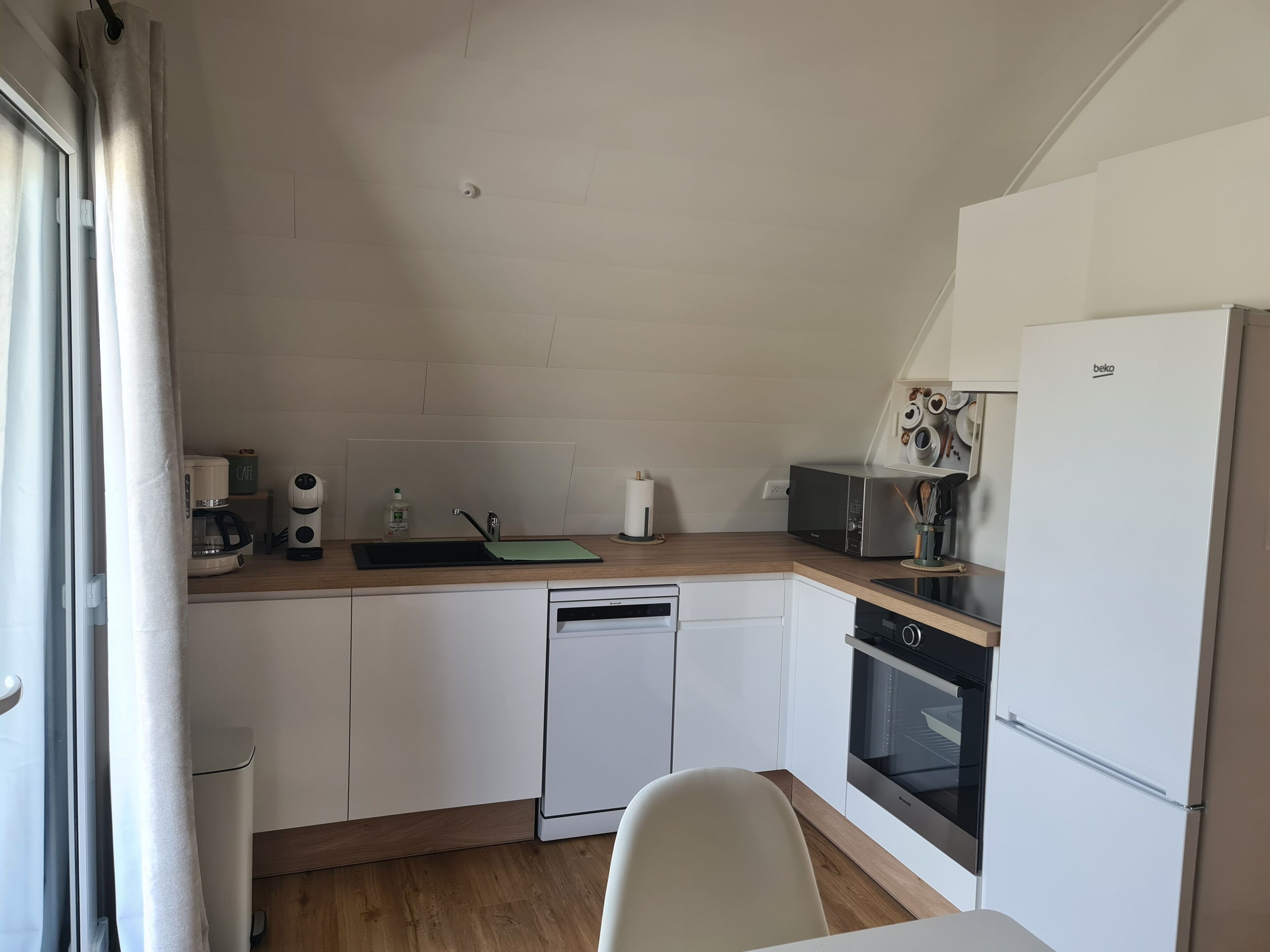 A compact kitchen with a dishwasher, microwave, and oven.