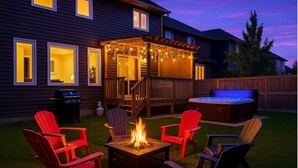 Ein Garten mit Feuerstelle, Gartenmöbeln, Whirlpool und einer Pergola mit Lichterketten.