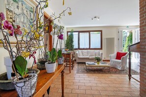 En stue med sofa, sofabord og potteplanter.