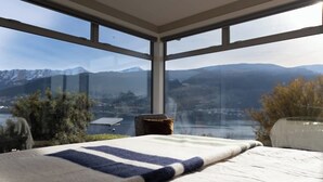 A room with a large window offering a mountain view. - Alpine Lake Home Summ (Kawarau Falls)