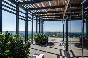 A covered outdoor terrace with a view of the cityscape.