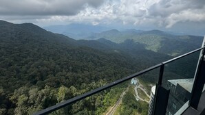 A panoramic view from a balcony overlooking a dense forested mountain range with a clear sky. - HAYWOOD HILLTOP WELLNESS LIVING (Genting Highlands)